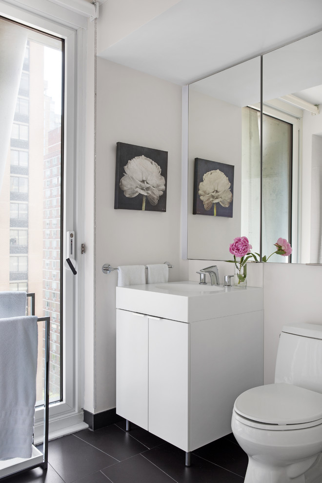 Inspiration for a small contemporary shower room bathroom in New York with flat-panel cabinets, white cabinets, a one-piece toilet, white walls, slate flooring, marble worktops, black floors, white worktops and an integrated sink.