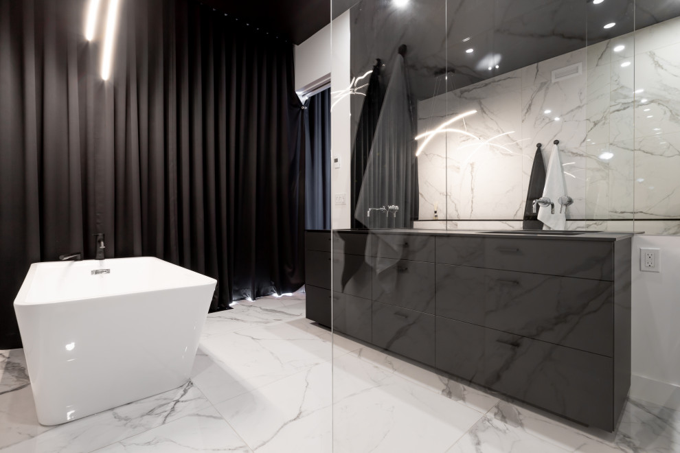 Photo of a large modern ensuite bathroom in New York with black cabinets, a freestanding bath, a walk-in shower, black and white tiles, ceramic tiles, multi-coloured walls, ceramic flooring, a built-in sink, engineered stone worktops, multi-coloured floors, an open shower, black worktops and double sinks.