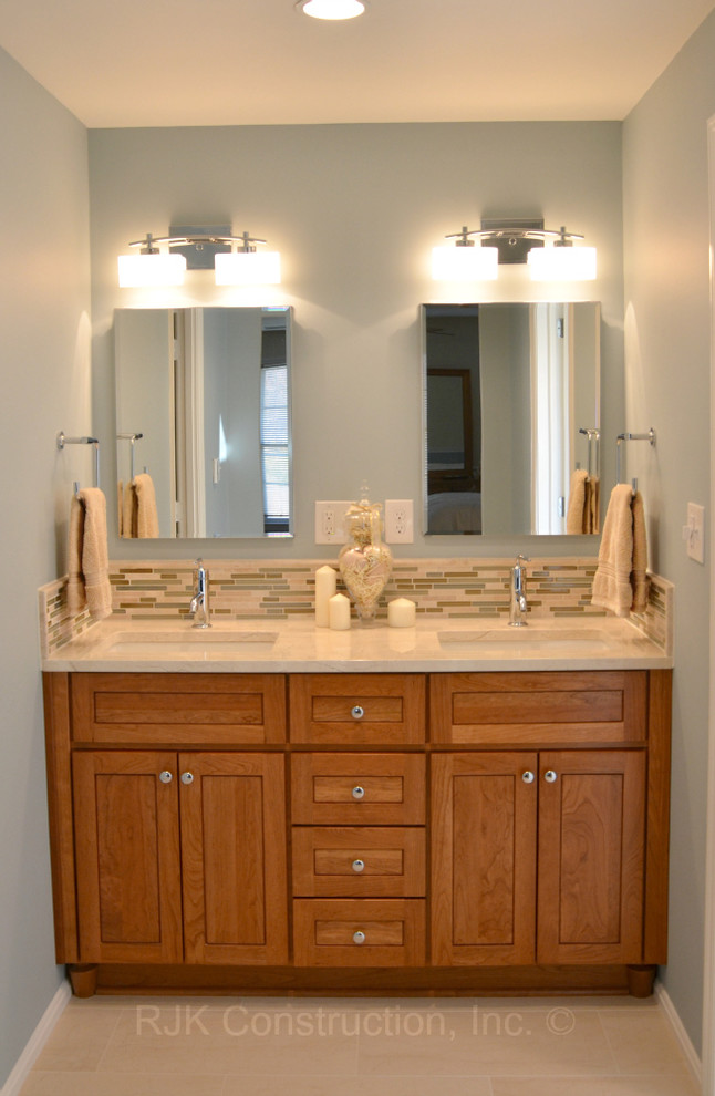 Elegant master beige tile bathroom photo in DC Metro with an undermount sink, recessed-panel cabinets, medium tone wood cabinets, a two-piece toilet and blue walls