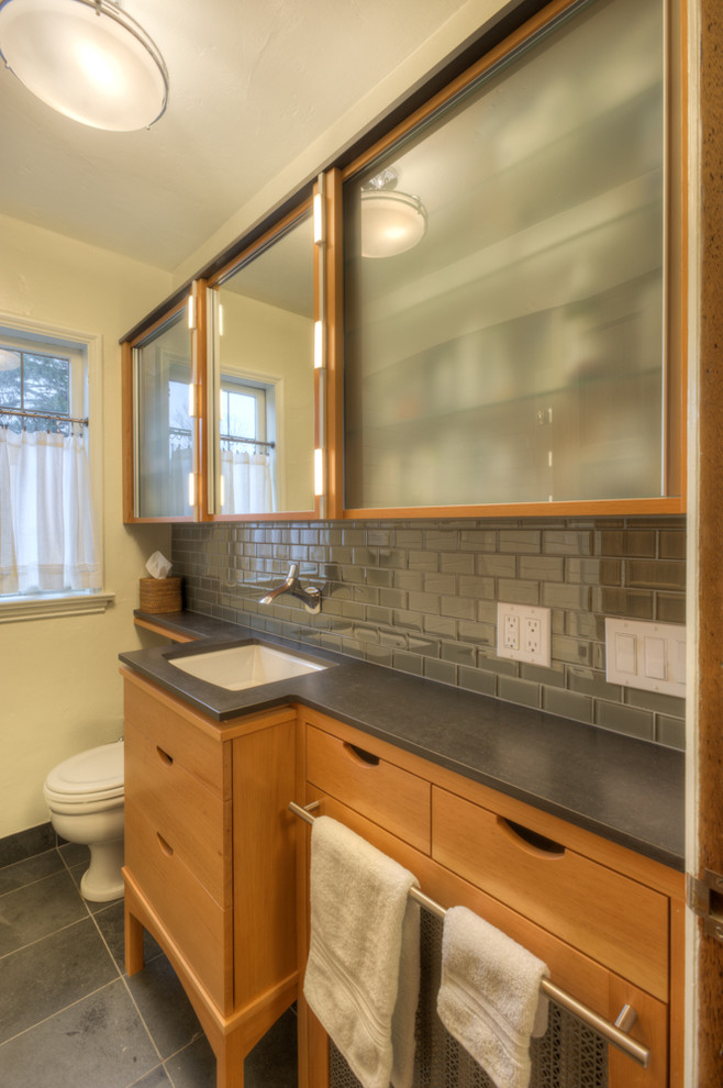 На фото: ванная комната среднего размера в современном стиле с плоскими фасадами, унитазом-моноблоком, плиткой кабанчик, желтыми стенами, темным паркетным полом, настольной раковиной и столешницей из дерева с