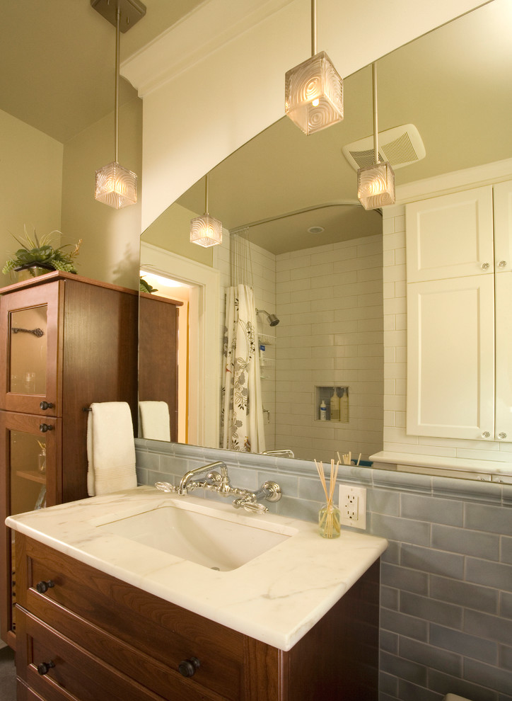 На фото: ванная комната среднего размера в стиле неоклассика (современная классика) с фасадами цвета дерева среднего тона, душем над ванной, синей плиткой, бежевыми стенами и душевой кабиной