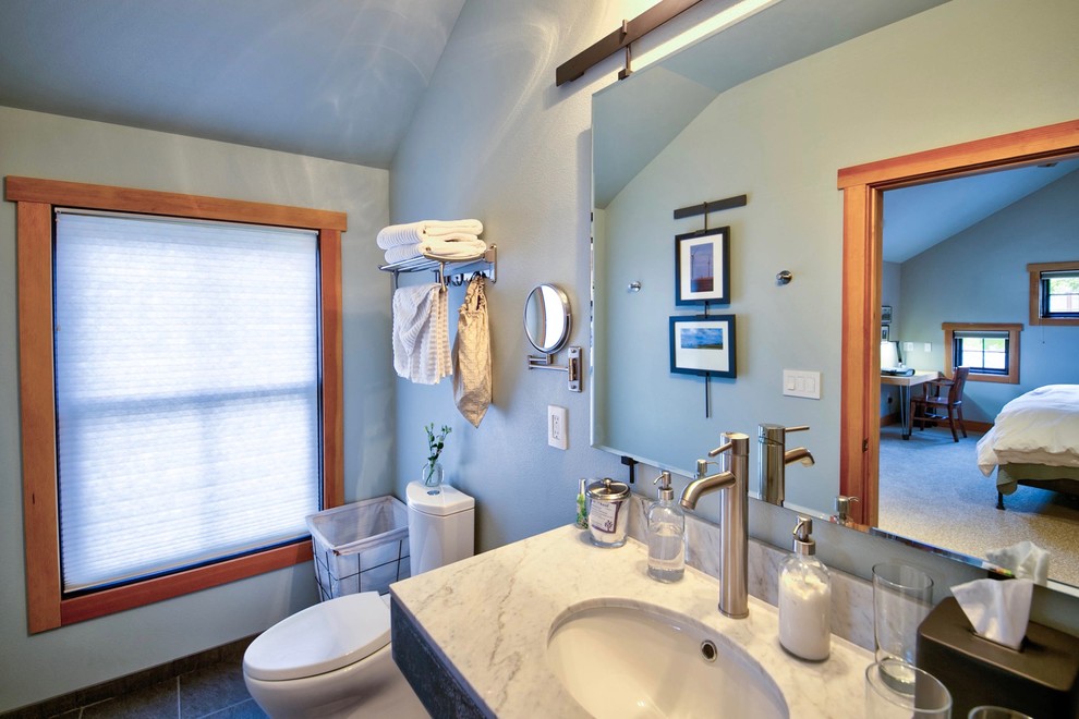 Cette image montre une salle de bain urbaine de taille moyenne avec une douche double, WC à poser, un carrelage blanc, des carreaux de porcelaine, un mur vert, un sol en carrelage de porcelaine, un lavabo encastré, un plan de toilette en marbre, un sol gris et une cabine de douche avec un rideau.