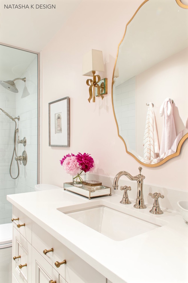 На фото: ванная комната среднего размера в стиле неоклассика (современная классика) с душем в нише, белой плиткой, плиткой кабанчик, розовыми стенами, полом из мозаичной плитки, душевой кабиной, врезной раковиной, столешницей из искусственного кварца, открытым душем и белой столешницей с