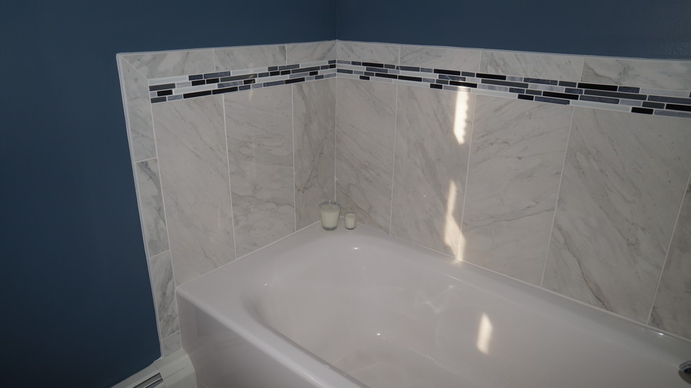 Photo of a medium sized traditional ensuite bathroom in Philadelphia with flat-panel cabinets, white cabinets, an alcove bath, an alcove shower, a two-piece toilet, grey tiles, porcelain tiles, blue walls, porcelain flooring, a submerged sink and granite worktops.
