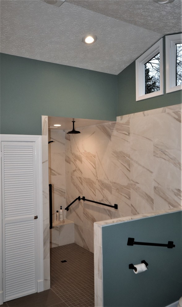 Inredning av ett klassiskt stort en-suite badrum, med ett fristående badkar, en kantlös dusch, en toalettstol med separat cisternkåpa, flerfärgad kakel, porslinskakel, gröna väggar, klinkergolv i porslin och ett väggmonterat handfat