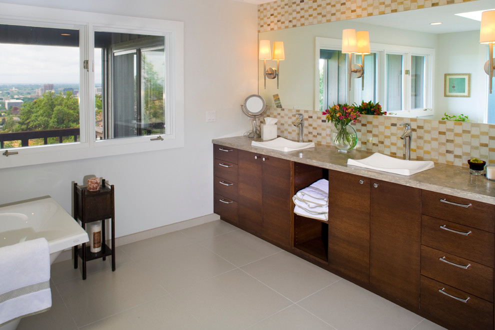 Design ideas for a large contemporary ensuite bathroom in Boise with a built-in sink, flat-panel cabinets, dark wood cabinets, limestone worktops, a freestanding bath, a corner shower, multi-coloured tiles, glass tiles, grey walls and ceramic flooring.
