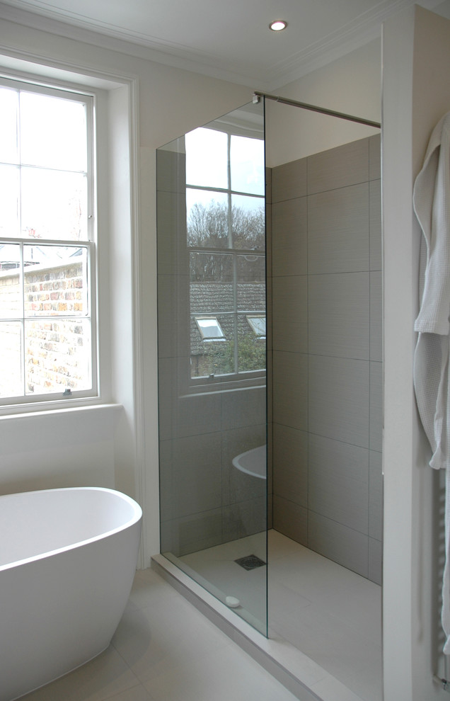 Foto di una stanza da bagno padronale minimalista di medie dimensioni con vasca freestanding, doccia aperta, piastrelle grigie, piastrelle in gres porcellanato, pareti grigie e pavimento in gres porcellanato