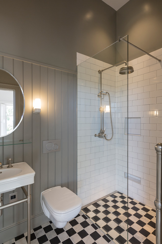Bild på ett litet vintage badrum med dusch, med en vägghängd toalettstol, vit kakel, tunnelbanekakel, ett konsol handfat, flerfärgat golv, med dusch som är öppen, en hörndusch och grå väggar