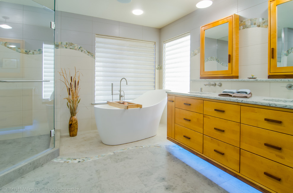 Large classic ensuite bathroom in Seattle with flat-panel cabinets, light wood cabinets, a freestanding bath, a corner shower, multi-coloured walls, a submerged sink, quartz worktops, beige floors and a hinged door.