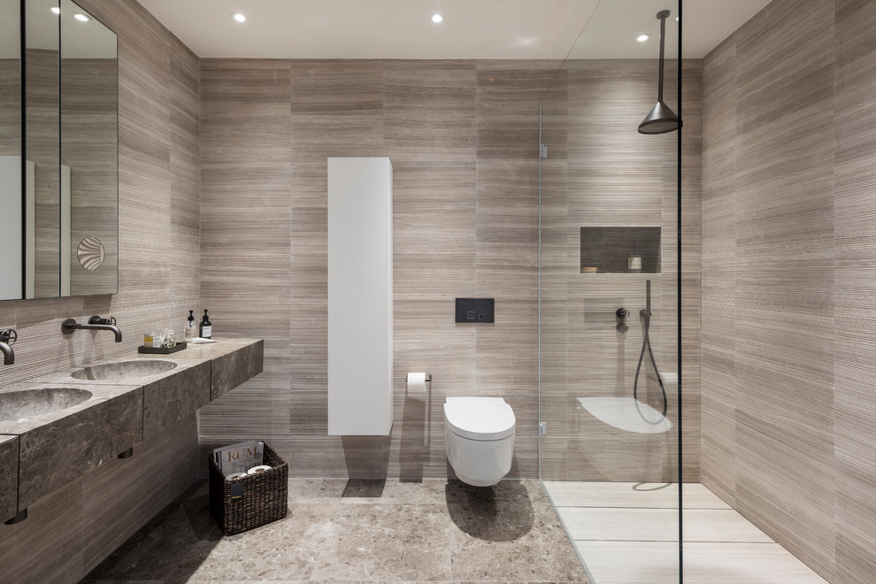 Ejemplo de cuarto de baño principal actual de tamaño medio sin sin inodoro con sanitario de pared, baldosas y/o azulejos beige, paredes grises y lavabo suspendido
