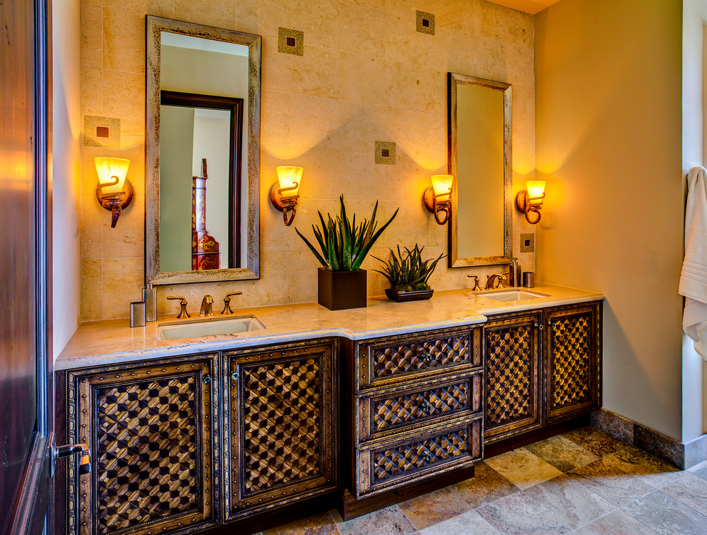 Immagine di una piccola stanza da bagno mediterranea con lavabo sottopiano, piastrelle beige, ante in legno scuro, top in laminato, piastrelle in pietra, pareti beige e doccia alcova
