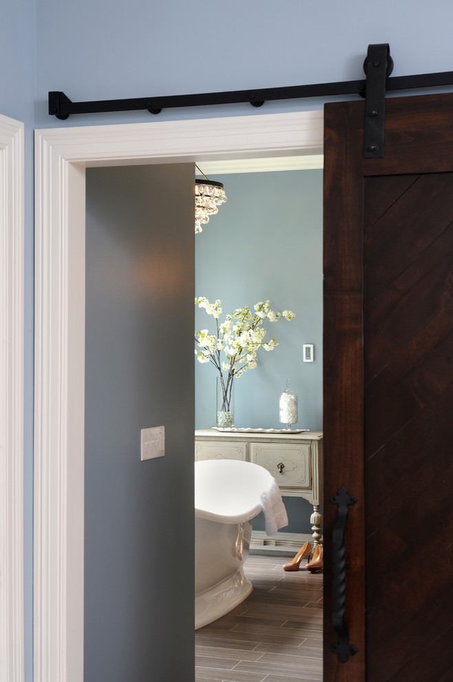 Imagen de cuarto de baño clásico con lavabo bajoencimera, puertas de armario de madera en tonos medios, encimera de mármol, bañera exenta y baldosas y/o azulejos de cerámica