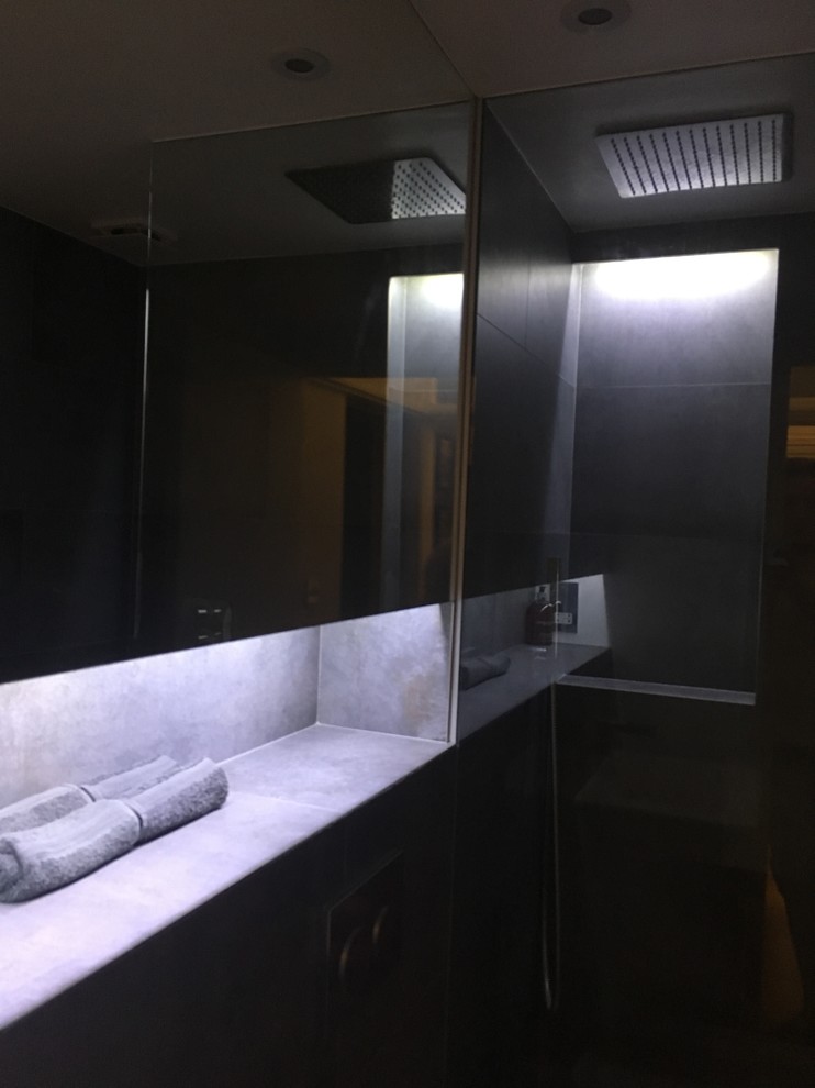 ロンドンにある小さなコンテンポラリースタイルのおしゃれな浴室 (白いキャビネット、オープン型シャワー、壁掛け式トイレ、グレーのタイル、磁器タイル、グレーの壁、磁器タイルの床、コンソール型シンク、タイルの洗面台) の写真