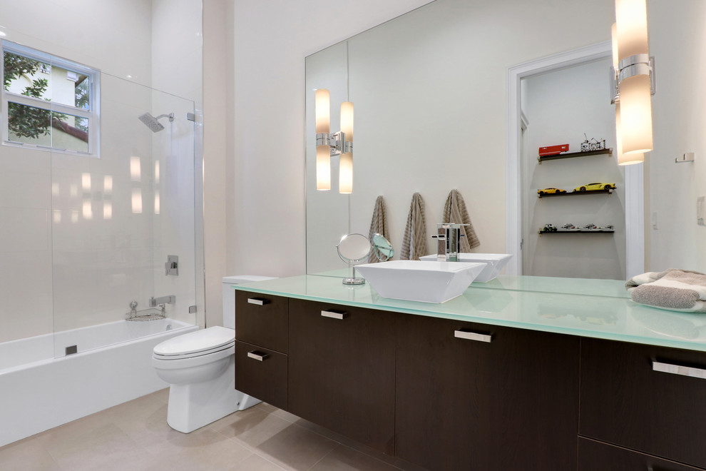 Großes Modernes Kinderbad mit weißen Schränken, Badewanne in Nische, Duschnische, Toilette mit Aufsatzspülkasten, Spiegelfliesen, weißer Wandfarbe, Unterbauwaschbecken, Glaswaschbecken/Glaswaschtisch und Falttür-Duschabtrennung in Miami
