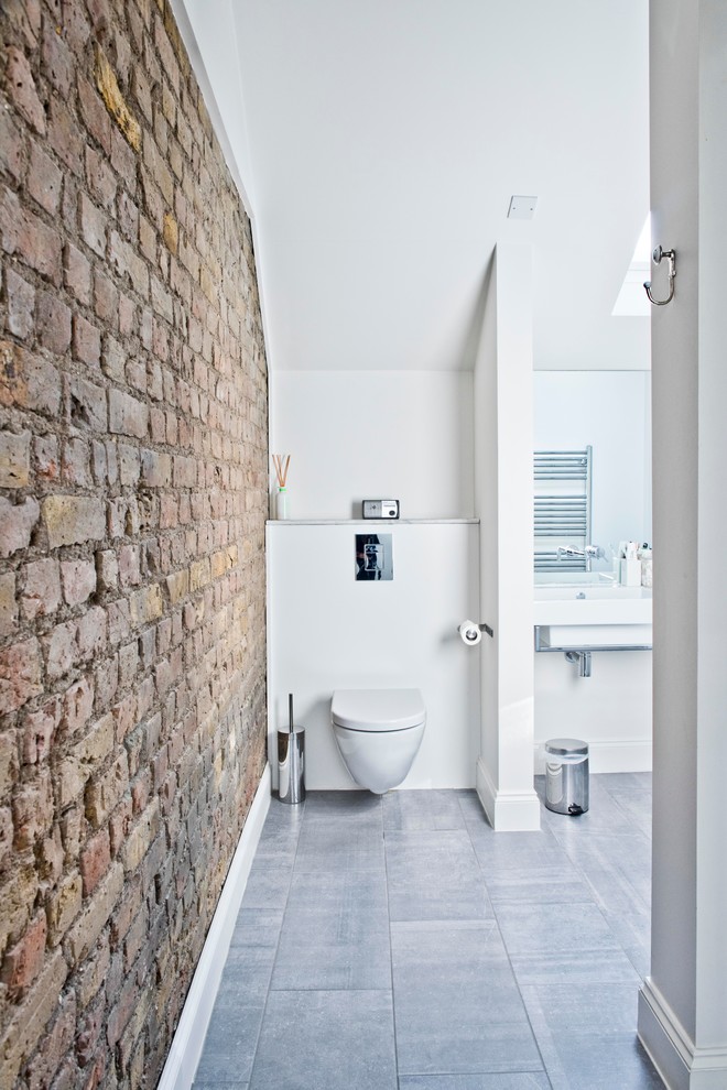 Idéer för funkis badrum, med en vägghängd toalettstol, vita väggar och ett väggmonterat handfat