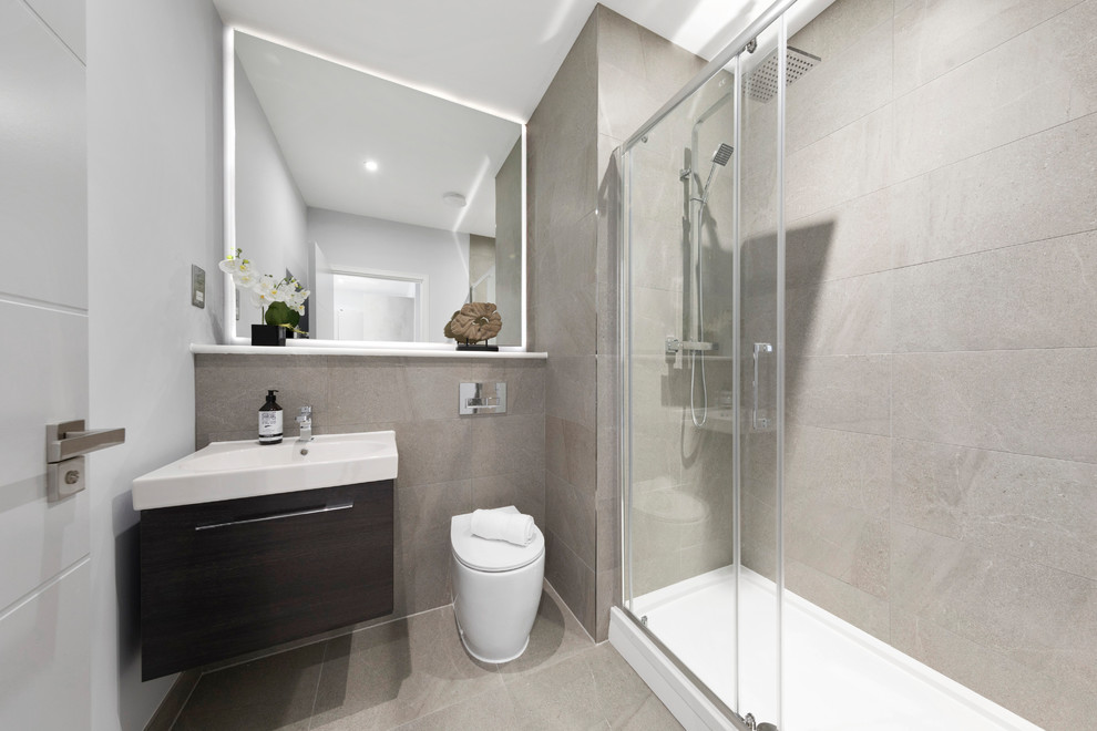 Foto di una stanza da bagno moderna con doccia aperta, piastrelle grigie, porta doccia scorrevole e top bianco
