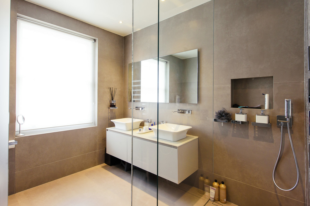Inspiration for a large contemporary ensuite bathroom in London with flat-panel cabinets, grey cabinets, a walk-in shower, a wall mounted toilet, brown tiles, ceramic tiles, brown walls, ceramic flooring and an integrated sink.