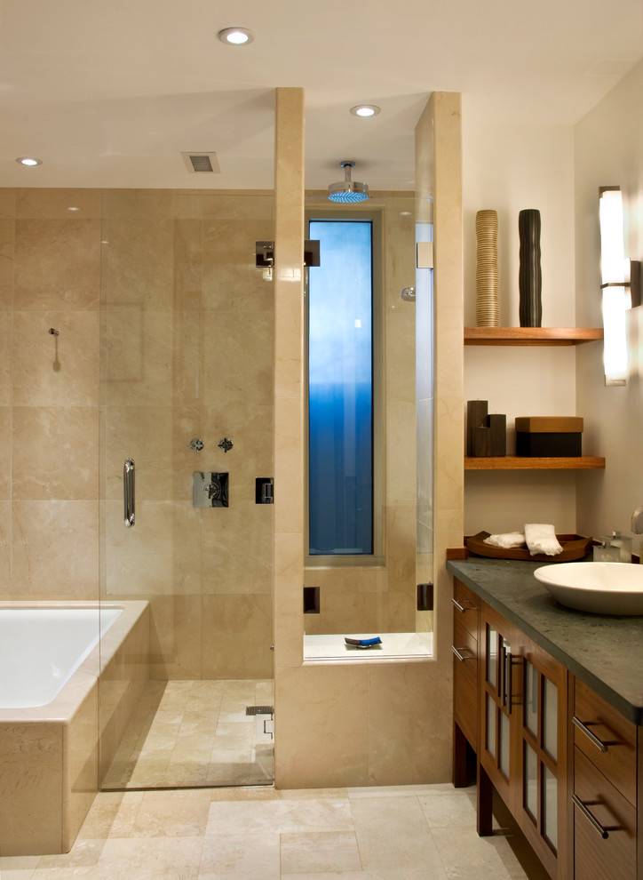 Cette photo montre une salle de bain principale tendance en bois brun de taille moyenne avec une vasque, un plan de toilette en stéatite, un placard à porte plane, une baignoire encastrée, un espace douche bain, un carrelage beige, un mur blanc, un sol en travertin, du carrelage en travertin et une fenêtre.