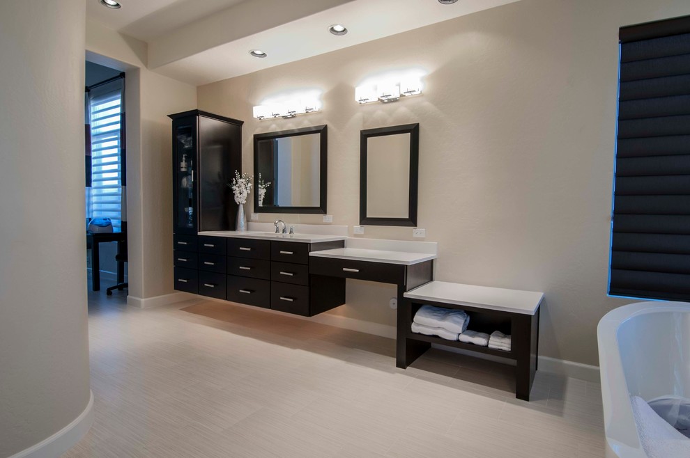 This is an example of a large modern ensuite bathroom in Phoenix with a built-in sink, raised-panel cabinets, dark wood cabinets, laminate worktops, a freestanding bath, a double shower, a one-piece toilet, white tiles, matchstick tiles, white walls and ceramic flooring.
