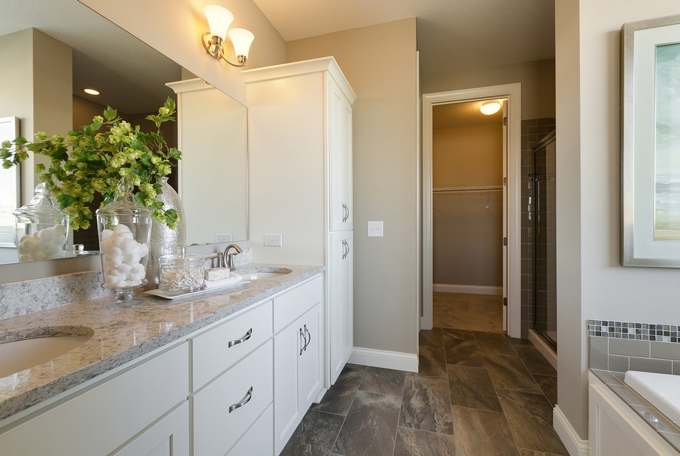 Exemple d'une salle de bain avec des portes de placard blanches, un plan de toilette en granite et un mur beige.
