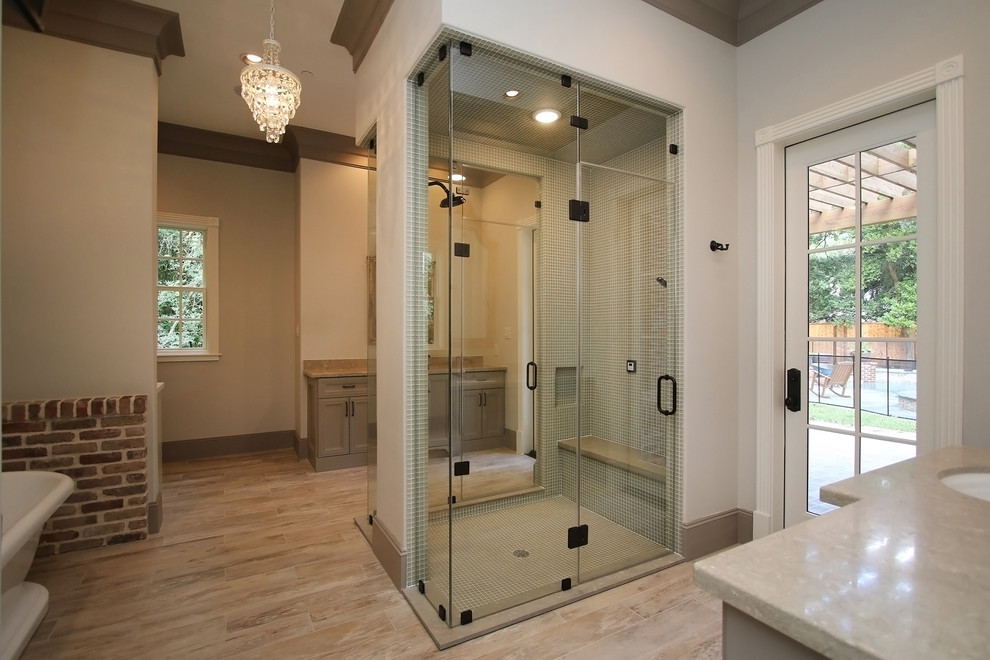 Inspiration for a medium sized classic ensuite bathroom in Houston with grey cabinets, a freestanding bath, granite worktops, recessed-panel cabinets, a built-in shower, grey tiles, mosaic tiles, beige walls, light hardwood flooring and a submerged sink.