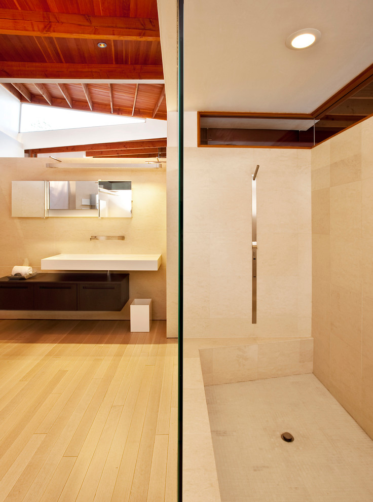 Idéer för funkis badrum, med ett väggmonterat handfat, släta luckor, skåp i mörkt trä och beige kakel