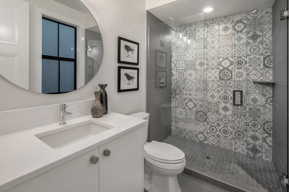 Inredning av ett lantligt stort vit vitt badrum med dusch, med släta luckor, vita skåp, vita väggar, ett undermonterad handfat, grått golv och dusch med gångjärnsdörr