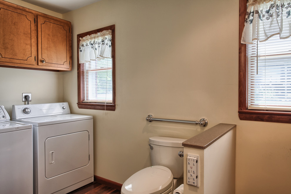 Klassisk inredning av ett stort badrum, med ett integrerad handfat, bänkskiva i akrylsten, en kantlös dusch, en bidé, brun kakel, beige väggar och vinylgolv