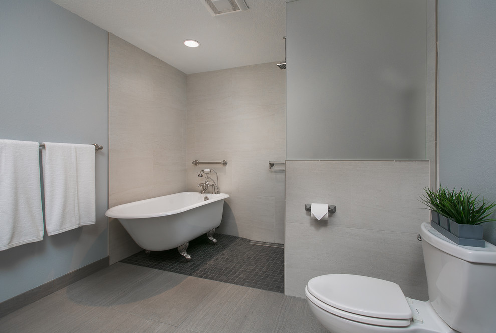 Photo of a large contemporary ensuite bathroom in Portland with a claw-foot bath, a walk-in shower, a two-piece toilet, grey tiles, porcelain tiles, grey walls, porcelain flooring, a submerged sink, soapstone worktops, open cabinets, medium wood cabinets, grey floors and an open shower.