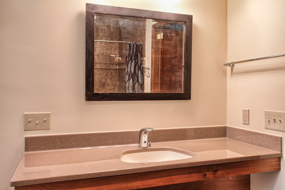 Ispirazione per una grande stanza da bagno classica con lavabo integrato, top in superficie solida, doccia a filo pavimento, piastrelle marroni, pareti beige e pavimento in vinile