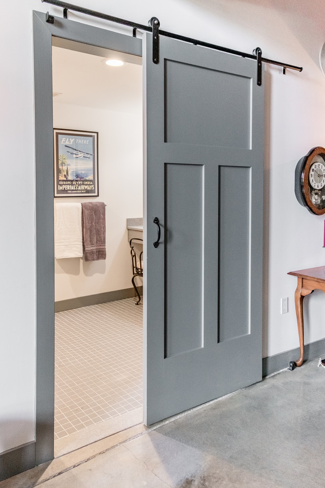 Exempel på ett mellanstort lantligt en-suite badrum, med skåp i shakerstil, grå skåp, en vägghängd toalettstol, vit kakel, vita väggar, bänkskiva i onyx, grått golv, en kantlös dusch, tunnelbanekakel, klinkergolv i keramik, dusch med duschdraperi och ett integrerad handfat