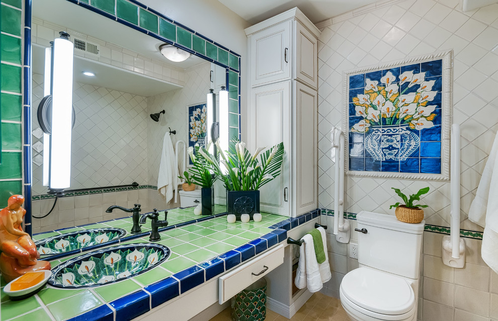Bild på ett mellanstort vintage grön grönt en-suite badrum, med luckor med upphöjd panel, vita skåp, en toalettstol med separat cisternkåpa, keramikplattor, vita väggar, klinkergolv i porslin, ett integrerad handfat, kaklad bänkskiva, en kantlös dusch, beiget golv, med dusch som är öppen och vit kakel
