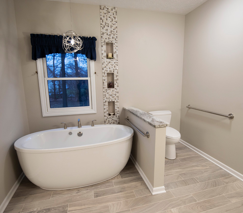Cette image montre une grande salle de bain principale traditionnelle avec une baignoire indépendante, une douche à l'italienne, un carrelage multicolore, des plaques de verre, un mur beige, un lavabo encastré, un plan de toilette en quartz, un sol beige et une cabine de douche à porte coulissante.