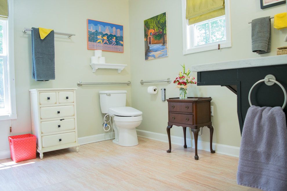 Modelo de cuarto de baño principal tradicional de tamaño medio con puertas de armario negras, ducha a ras de suelo, sanitario de dos piezas, paredes verdes, suelo de corcho, encimera de granito y suelo beige