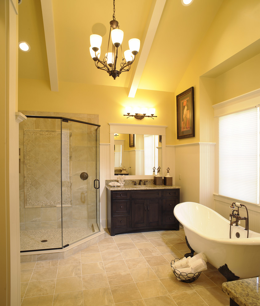 Klassisk inredning av ett en-suite badrum, med skåp i shakerstil, skåp i mörkt trä, ett fristående badkar, en öppen dusch, gula väggar, ett undermonterad handfat, granitbänkskiva och med dusch som är öppen