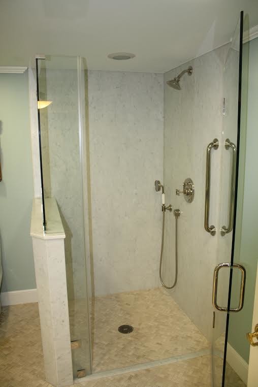 Immagine di una piccola stanza da bagno con doccia contemporanea con ante lisce, ante in legno bruno, doccia alcova, pareti blu, pavimento con piastrelle a mosaico, lavabo sottopiano e top in marmo