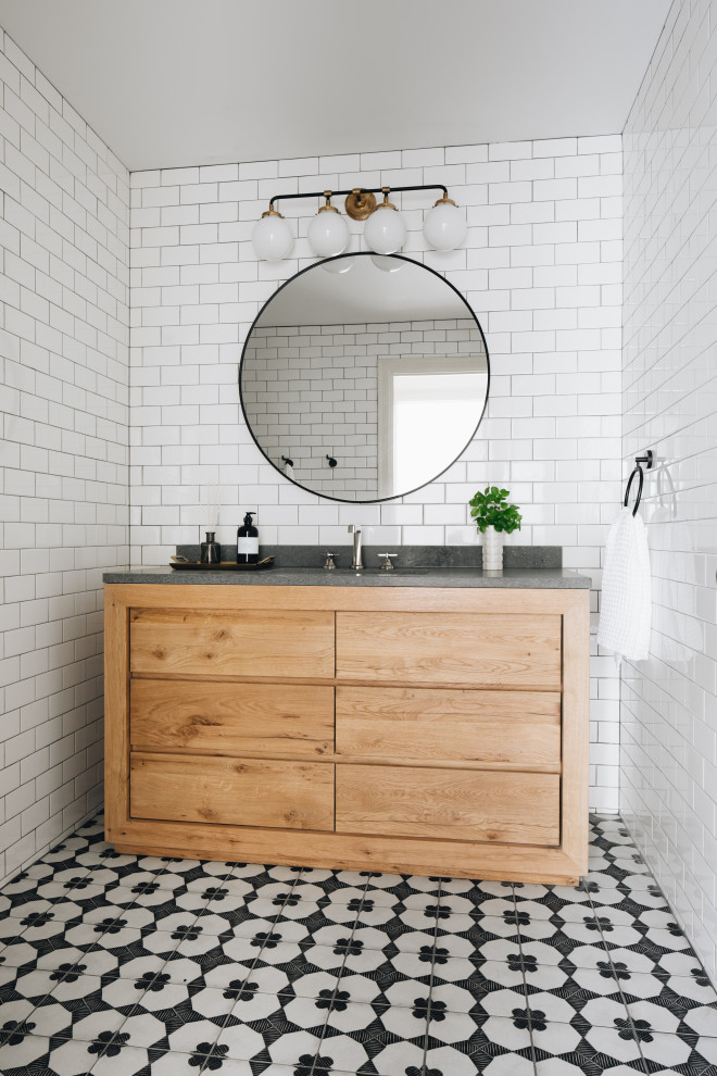 Inspiration for a transitional white tile and ceramic tile porcelain tile, black floor and single-sink bathroom remodel in Grand Rapids with flat-panel cabinets, light wood cabinets, white walls, an undermount sink, quartzite countertops, gray countertops and a freestanding vanity