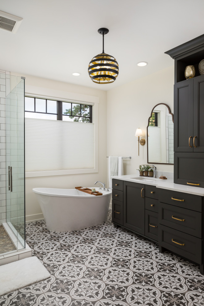 Photo of a classic bathroom in Grand Rapids with recessed-panel cabinets, black cabinets, a freestanding bath, white walls, a submerged sink, multi-coloured floors and white worktops.