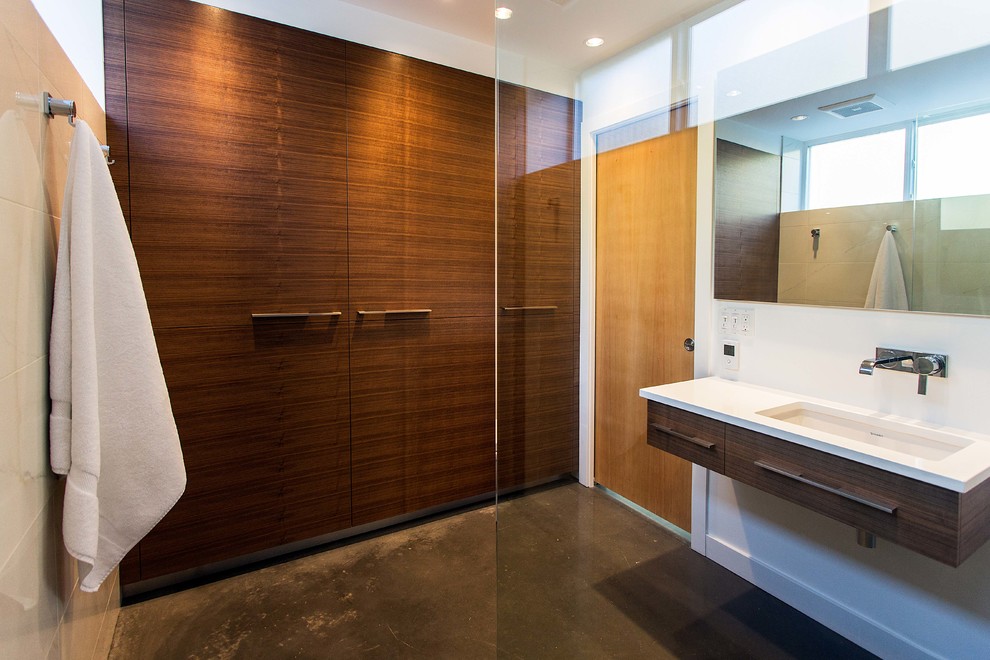 Cette image montre une salle de bain design avec un placard à porte plane, une douche ouverte, un mur blanc, sol en béton ciré et aucune cabine.