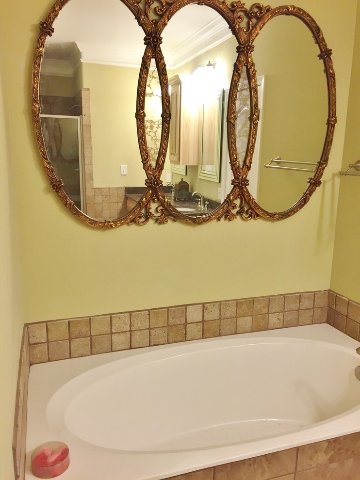Inredning av ett klassiskt mellanstort en-suite badrum, med ett undermonterad handfat, luckor med upphöjd panel, skåp i ljust trä, ett platsbyggt badkar, en toalettstol med hel cisternkåpa, brun kakel, keramikplattor, beige väggar och klinkergolv i keramik