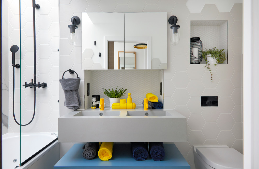 This is an example of a small contemporary family bathroom in London with glass-front cabinets, a built-in bath, a shower/bath combination, a one-piece toilet, white tiles, ceramic tiles, white walls and a hinged door.