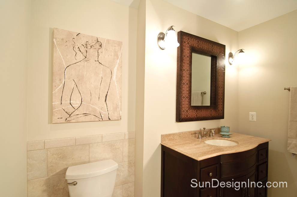 Immagine di una stanza da bagno tradizionale con lavabo sottopiano, ante a filo, ante in legno bruno, top in granito, WC a due pezzi, piastrelle beige, pareti beige e pavimento in gres porcellanato