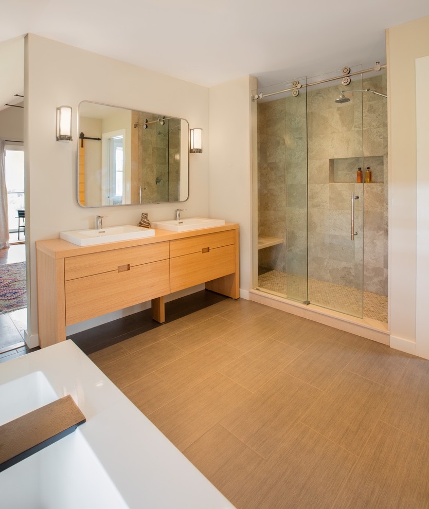 Пример оригинального дизайна: ванная комната в стиле кантри с светлыми деревянными фасадами, отдельно стоящей ванной, керамической плиткой и полом из керамической плитки