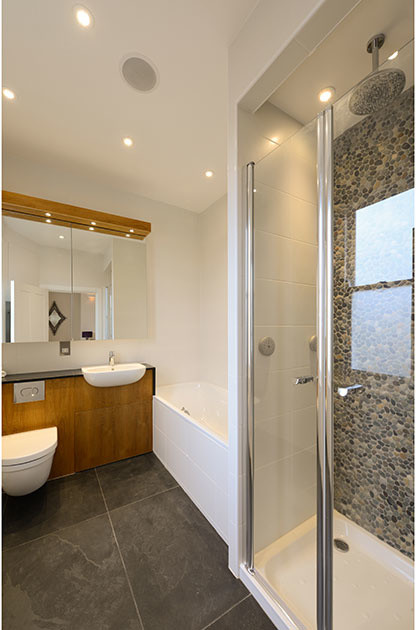Example of a trendy master multicolored tile, white tile and pebble tile ceramic tile and gray floor walk-in shower design in London with glass-front cabinets, a wall-mount toilet and white walls
