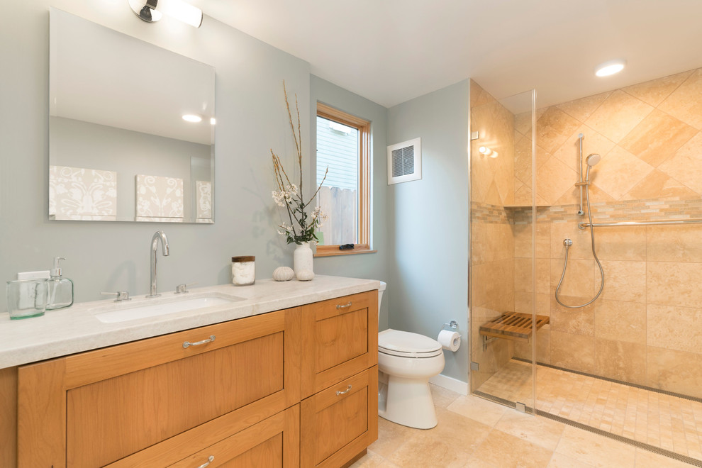 Small arts and crafts master blue tile and travertine tile travertine floor and beige floor walk-in shower photo in San Francisco with shaker cabinets, medium tone wood cabinets, a two-piece toilet, blue walls, an undermount sink, quartzite countertops, a hinged shower door and beige countertops
