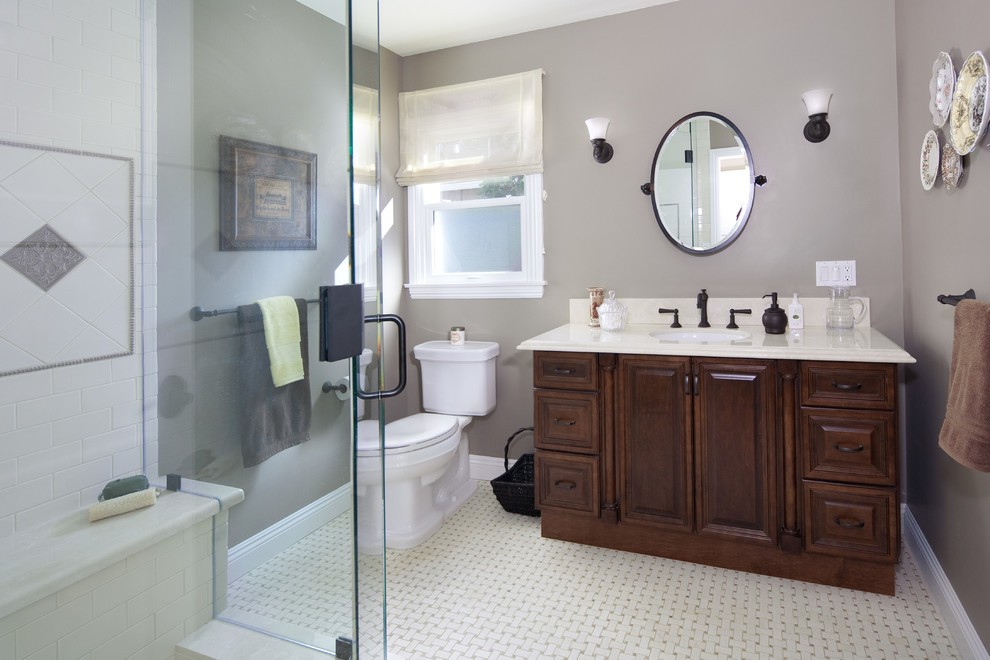 Стильный дизайн: главная ванная комната среднего размера в классическом стиле с фасадами с выступающей филенкой, темными деревянными фасадами, угловым душем, раздельным унитазом, серыми стенами, полом из керамогранита и врезной раковиной - последний тренд