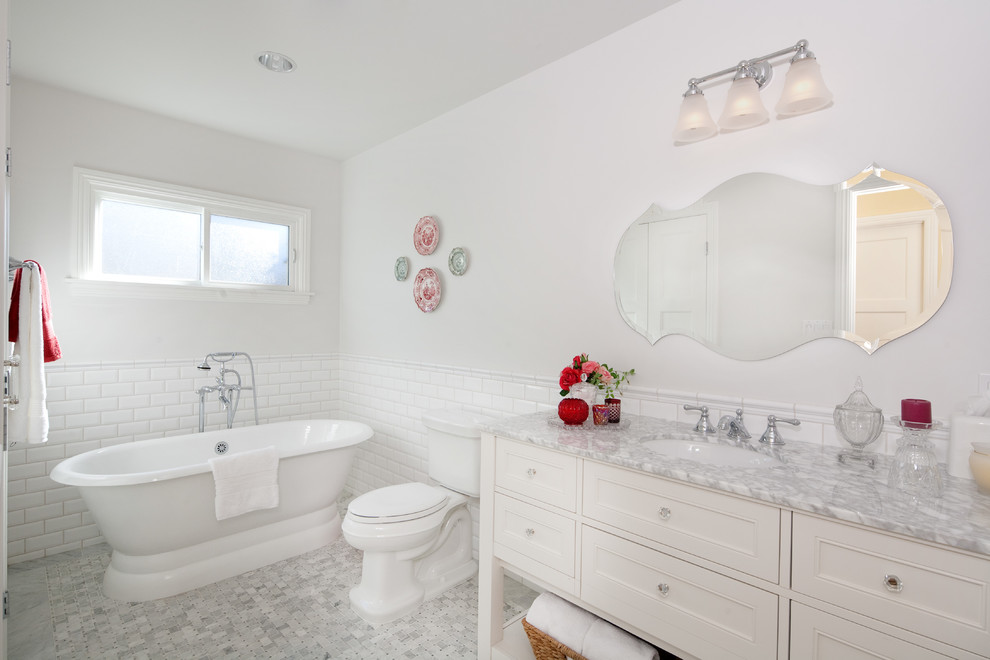 Example of a mid-sized classic 3/4 white tile and subway tile porcelain tile freestanding bathtub design in Los Angeles with recessed-panel cabinets, white cabinets, a two-piece toilet, white walls, an undermount sink, marble countertops and gray countertops