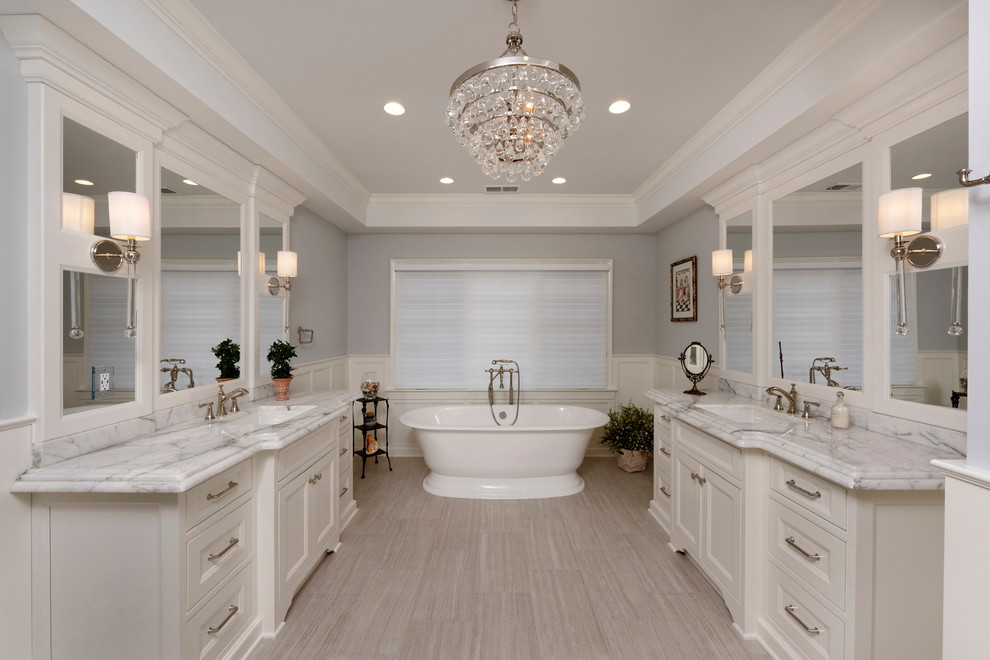 Klassisk inredning av ett stort grå grått en-suite badrum, med skåp i shakerstil, vita skåp, ett fristående badkar, grå väggar, klinkergolv i porslin, ett undermonterad handfat, marmorbänkskiva och grått golv