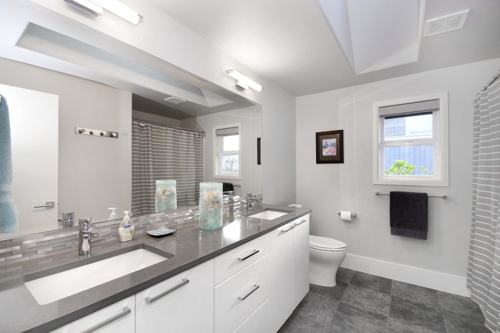 Inredning av ett modernt stort grå grått badrum med dusch, med släta luckor, vita skåp, en toalettstol med separat cisternkåpa, bruna väggar, klinkergolv i porslin, ett undermonterad handfat och grått golv