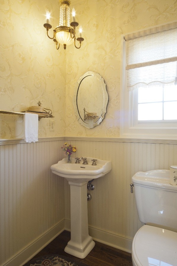 Idéer för att renovera ett litet vintage badrum, med ett piedestal handfat, en toalettstol med separat cisternkåpa, gula väggar och mörkt trägolv